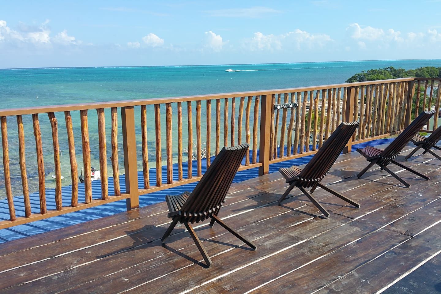 Une terrasse en bois avec des chaises longues donnant sur une étendue d’eau.