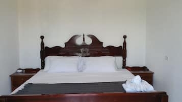 A standard single bed with a wooden headboard and two bedside tables.