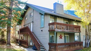 A two-story house with a wooden deck and a staircase leading to the upper level. - Walk 2 Baldy/River, Pool,Hot Tub, Bikes, Private Ski Locker at Mtn, Grt reviews  (Ketchum)