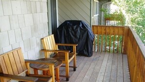 A wooden deck with two wooden chairs and a covered grill. - Walk 2 Baldy/River, Pool,Hot Tub, Bikes, Private Ski Locker at Mtn, Grt reviews  (Ketchum)