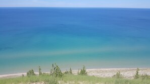 A coastal landscape with a clear view of the sea and a sandy beach in the foreground. - Beautiful Lakefront Home, Central AC, Paddle to Lake Michigan, Dock, Beach, Raft (Frankfort)