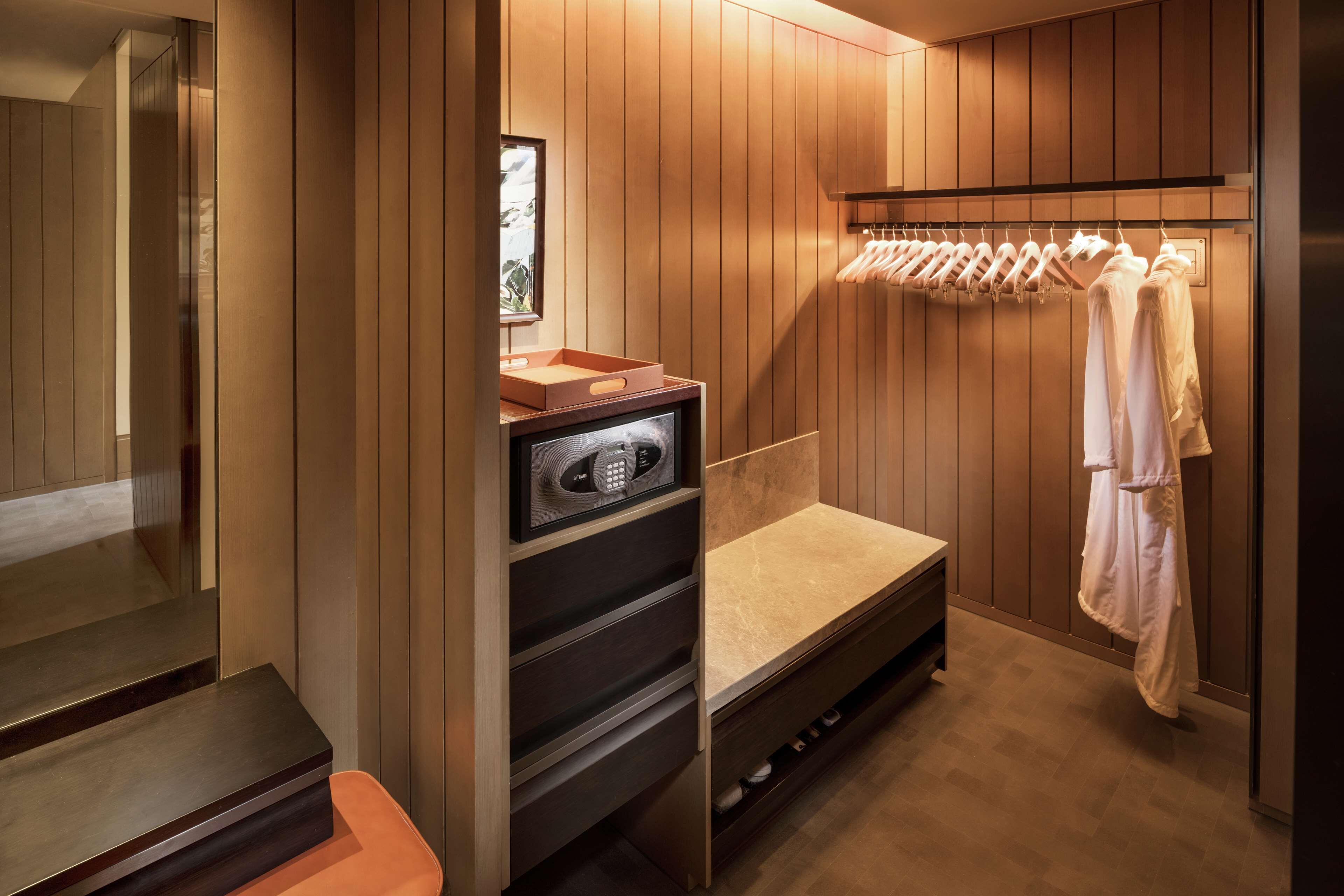 A modern bathroom with a wooden vanity, a built-in heater, and a towel rack.