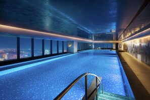 An indoor infinity pool with a city view, modern design, and a glass barrier. - Conrad Shenyang (Shenyang)