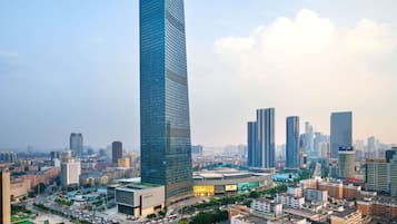 A high-rise building with a modern glass facade, surrounded by a cityscape with various other buildings.