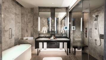 A modern bathroom with a freestanding bathtub, a large mirror, and a glass-enclosed shower area.