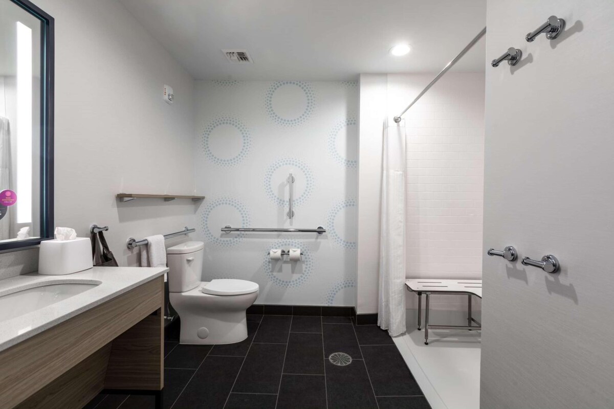 Un baño moderno con inodoro, lavabo y zona de ducha.