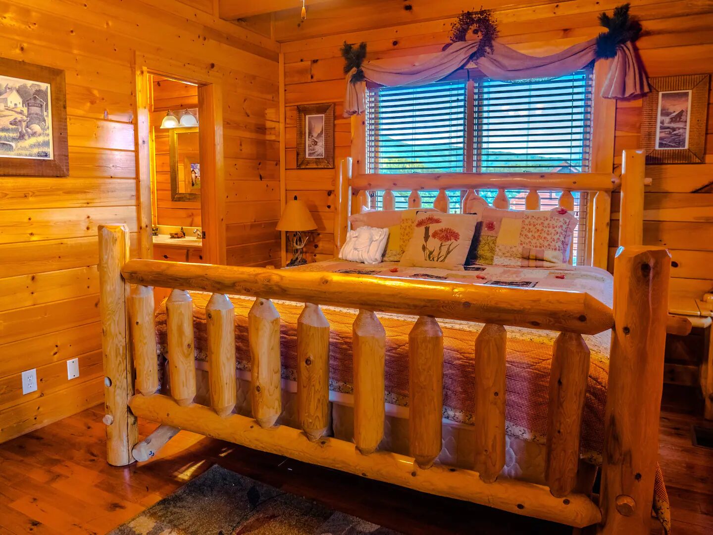 L’intérieur d’un chalet en bois, avec un lit, des murs en bois et une fenêtre équipée de stores.