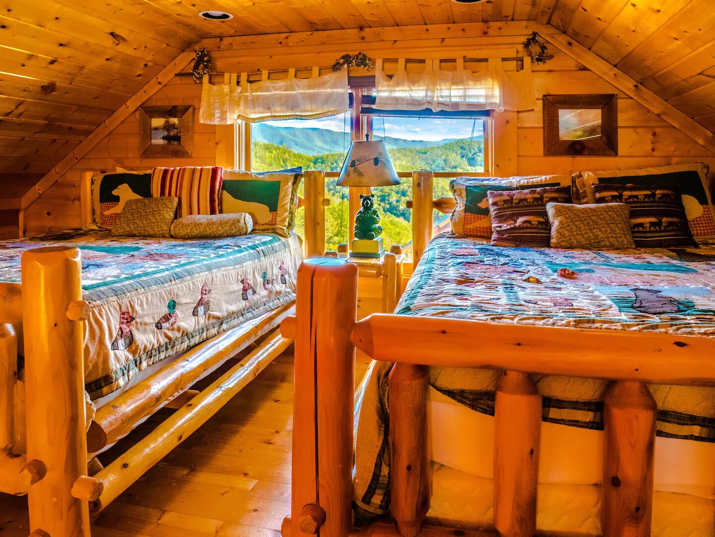 A cozy cabin with two wooden beds, a window with a mountain view, and a rustic interior.