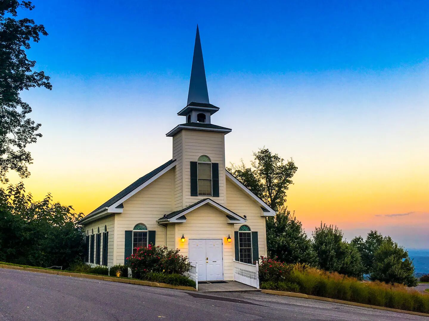 A church with a steeple, a white door, and a small porch.