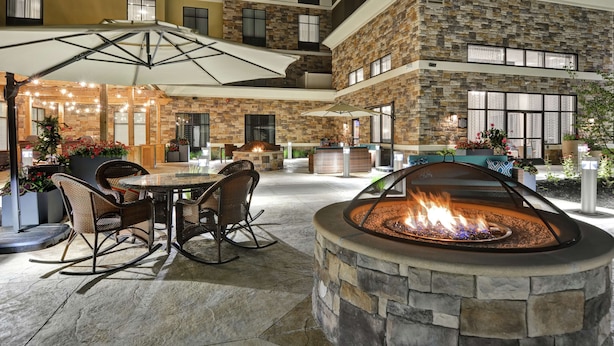 A courtyard with a fire pit, outdoor seating, and a covered area with string lights. - Homewood Suites by Hilton Poughkeepsie (Poughkeepsie)