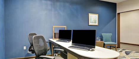 Une salle de conférence équipée de deux ordinateurs portables, d’une table en bois et de deux chaises de bureau.