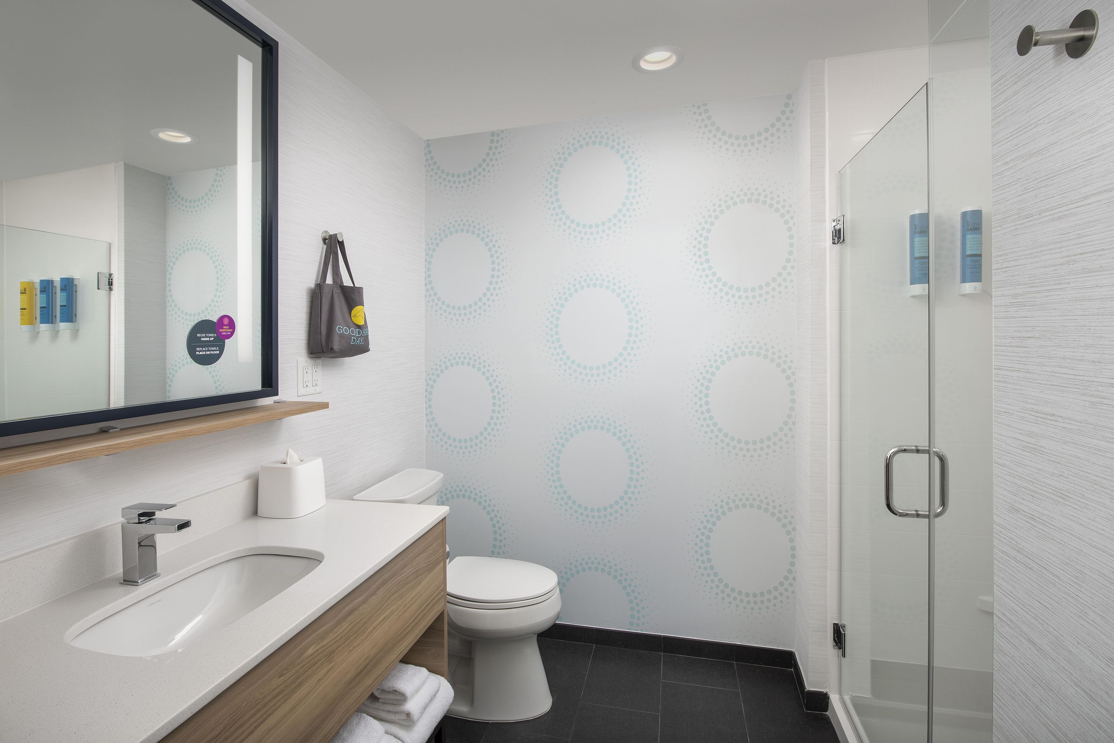 A modern bathroom with a sink, toilet, and shower.
