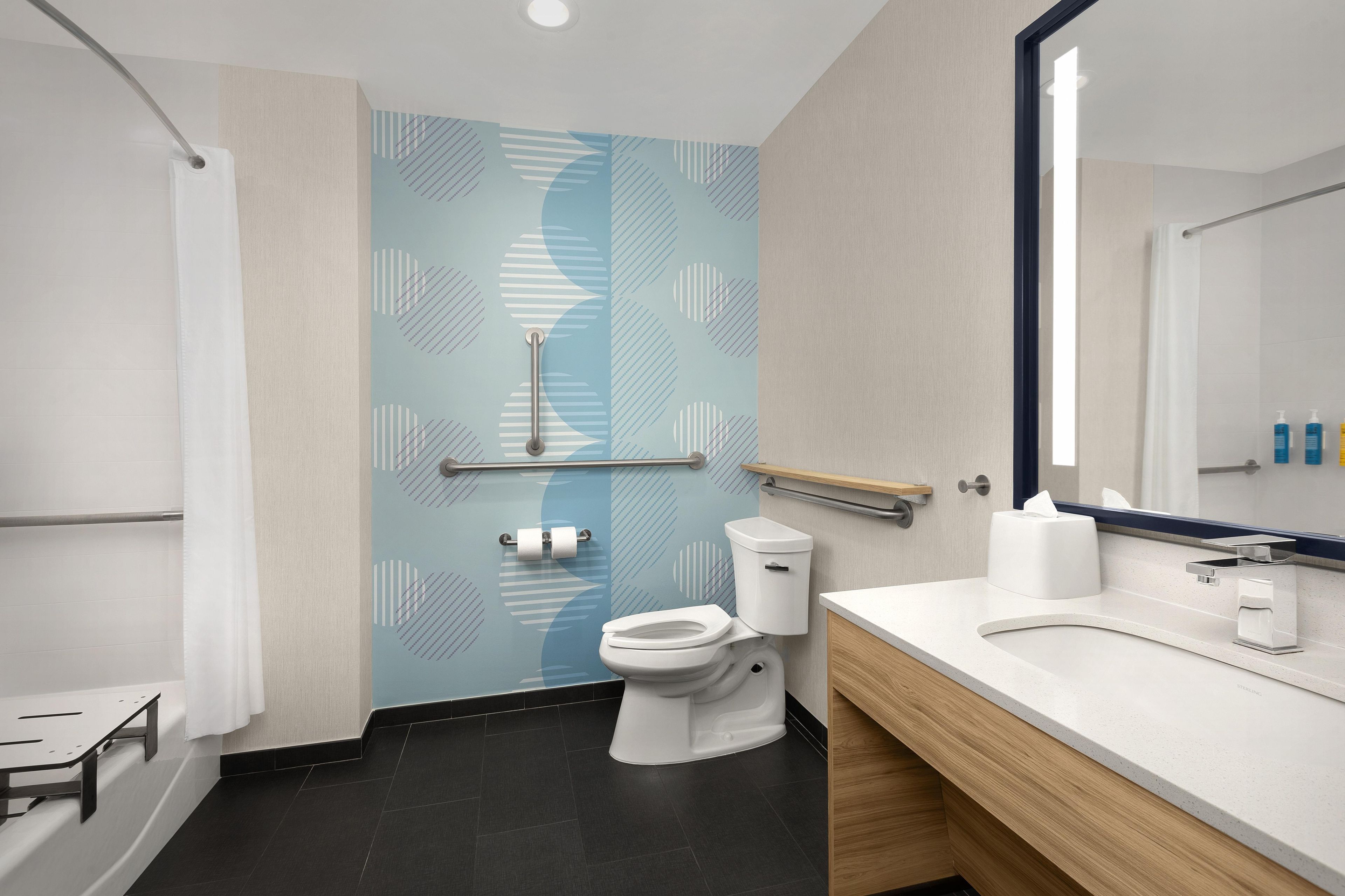 A modern bathroom with a toilet, sink, and mirror.
