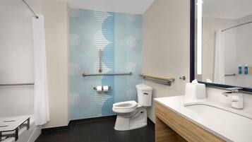 A modern bathroom with a toilet, sink, and mirror.