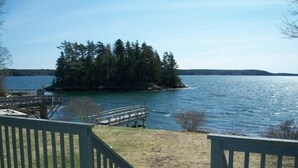 A wooden dock extending into a lake with a small island of trees in the background. - Spectacular Waterfront Retreat Close To Portland!   (West Bath)