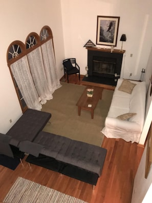 Ein Wohnzimmer mit einer Couch, einem Couchtisch, einem Kamin und einem Sessel.