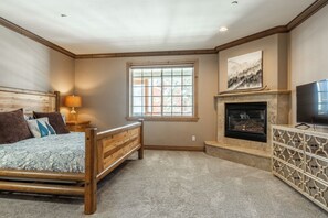 A bedroom with a wooden bed, a fireplace, a television, and a window. - Walk to Canyon Lodge | Noble Nest + Hot Tub/Sauna + 2-Car Garage (Mammoth)