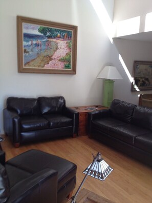 Relax in a stylish living room with two comfortable sofas, a coffee table, and a floor lamp.