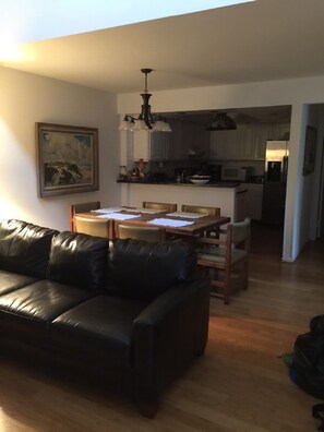 Relax in the living room with a comfortable sofa, dining area, and fully equipped kitchen.