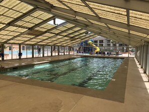 An indoor swimming pool with a covered roof, clear water, and a slide area in the background. - LAS PALMAS | 2BD/2BTH Condo (St. George)