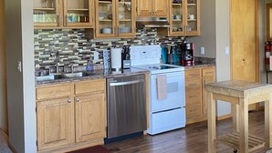 Una cocina con armarios de madera, una estufa y un lavabo.