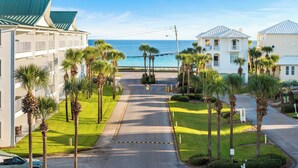 Un hôtel situé sur la côte, offrant une vue sur l’océan, des palmiers et doté d’une entrée sécurisée.