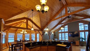 A spacious kitchen with wooden cabinets, a large island, and pendant lighting. - Kemp's Rentals Luxurious Executive Retreat Portage Lake-Beach-Firepit & Pavilion (Hancock)