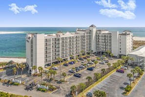 A multi-story hotel with a parking lot, located near a beach. - Grand Pointe 502- Gulf-front, water on 2 sides (Orange Beach)