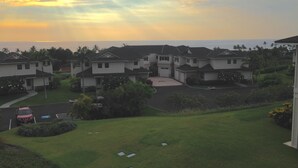 A residential area with houses, a parking lot, and a grassy area. - AWESOME OCEANVIEW 3 BEDROOM 3 BATH TOWNHOME UNBEATABLE LOCATION (Kailua-Kona)