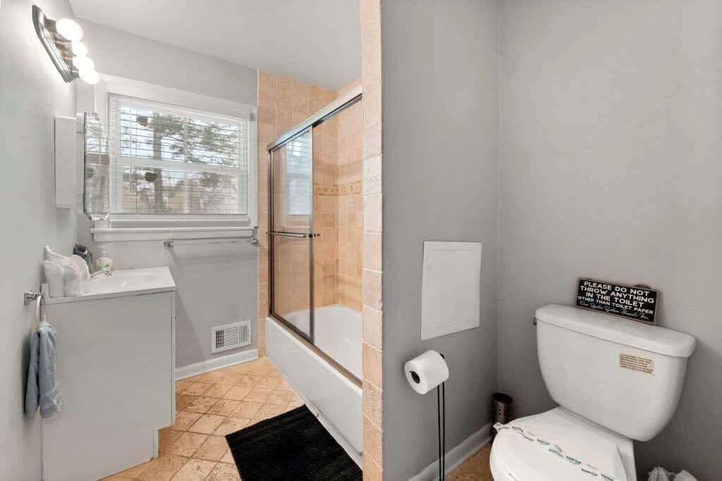 A bathroom with a shower, toilet, and sink.