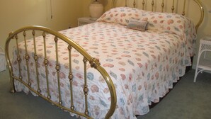 A bed with a floral bedspread, a bedside table with a lamp, and a nightstand with a lamp. - In-town Lewes location is near shops, museums, parks, bay and ocean beaches. (Lewes)