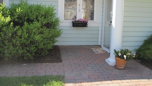 A house with a number 412 window, a brick pathway, and a potted plant. - In-town Lewes location is near shops, museums, parks, bay and ocean beaches. (Lewes)