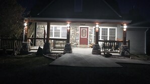 Een lodge met een stenen gevel, een houten veranda en een stenen schoorsteen.