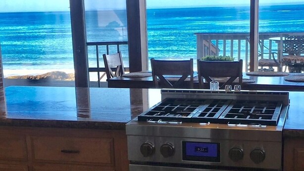 A kitchen with a gas stove and oven, large windows with a view of the ocean. - Best Location! Best View! - EXCLUSIVELY ON VRBO (Cayucos)