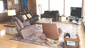 A living room with a sofa, armchair, coffee table, and a television. - Best Location! Best View! - EXCLUSIVELY ON VRBO (Cayucos)