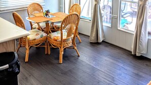 A dining area with a table and chairs, a ceiling fan, and large windows with curtains. - Relax by Florida Keys Beaches, just a 7-min drive away (Cudjoe Key)