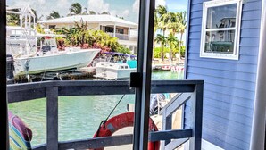 A view from a balcony with a pool, a chair, and a lifebuoy. - Relax by Florida Keys Beaches, just a 7-min drive away (Cudjoe Key)