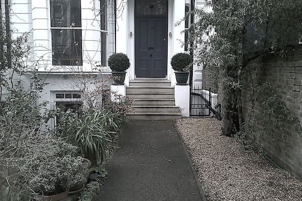 Approaching the front door with the apartment bay window to the left.