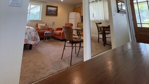 A living room with a sofa, armchairs, a coffee table, and a dining area with a table and chairs. - Footsteps to Hawaii's Best Beach  (Kailua)