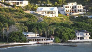 A coastal property with multiple buildings, a dock, and a road leading up the hill. - Architecturally Designed Villa in Paradise, Quiet Beach & Blue Water Views (Turtle Beach)