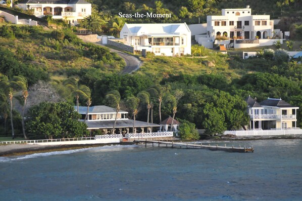 A coastal property with multiple buildings, a dock, and a road leading up the hill. - Architecturally Designed Villa in Paradise, Quiet Beach & Blue Water Views (Turtle Beach)