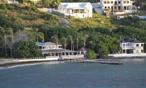 A coastal property with multiple buildings, a dock, and a road leading up the hill. - Architecturally Designed Villa in Paradise, Quiet Beach & Blue Water Views (Turtle Beach)