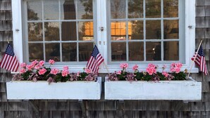 Two windows with white frames and pink flowers in front. - The Quintessential Traditional Nantucket Vacation! (Nantucket)