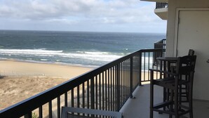A balcony with a view of the ocean, a table, and two chairs. - Ocean Front, North Ocean City, Maryland  (Ocean City)
