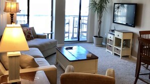 A living room with a sofa, armchair, coffee table, lamp, TV, and a plant. - Ocean Front, North Ocean City, Maryland  (Ocean City)
