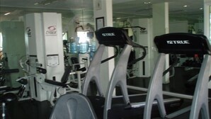 A gym with treadmills, weight machines, and a water cooler.