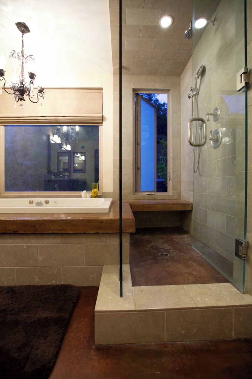 Un baño moderno con bañera, ducha y un ventanal grande.