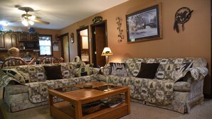 A living room with a sofa, a coffee table, and a ceiling fan.