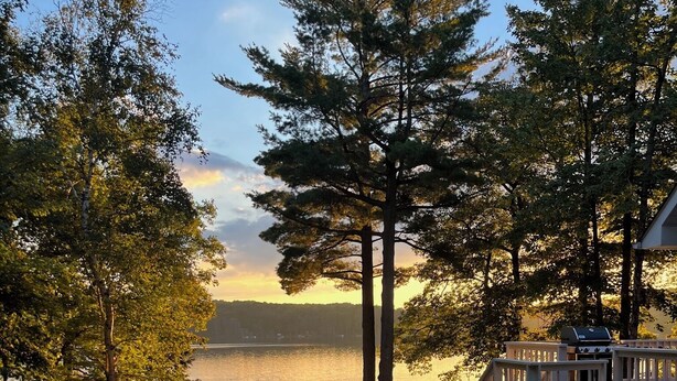 Una terrazza sul lago con posti a sedere all'aperto e una scala che conduce a una zona coperta.