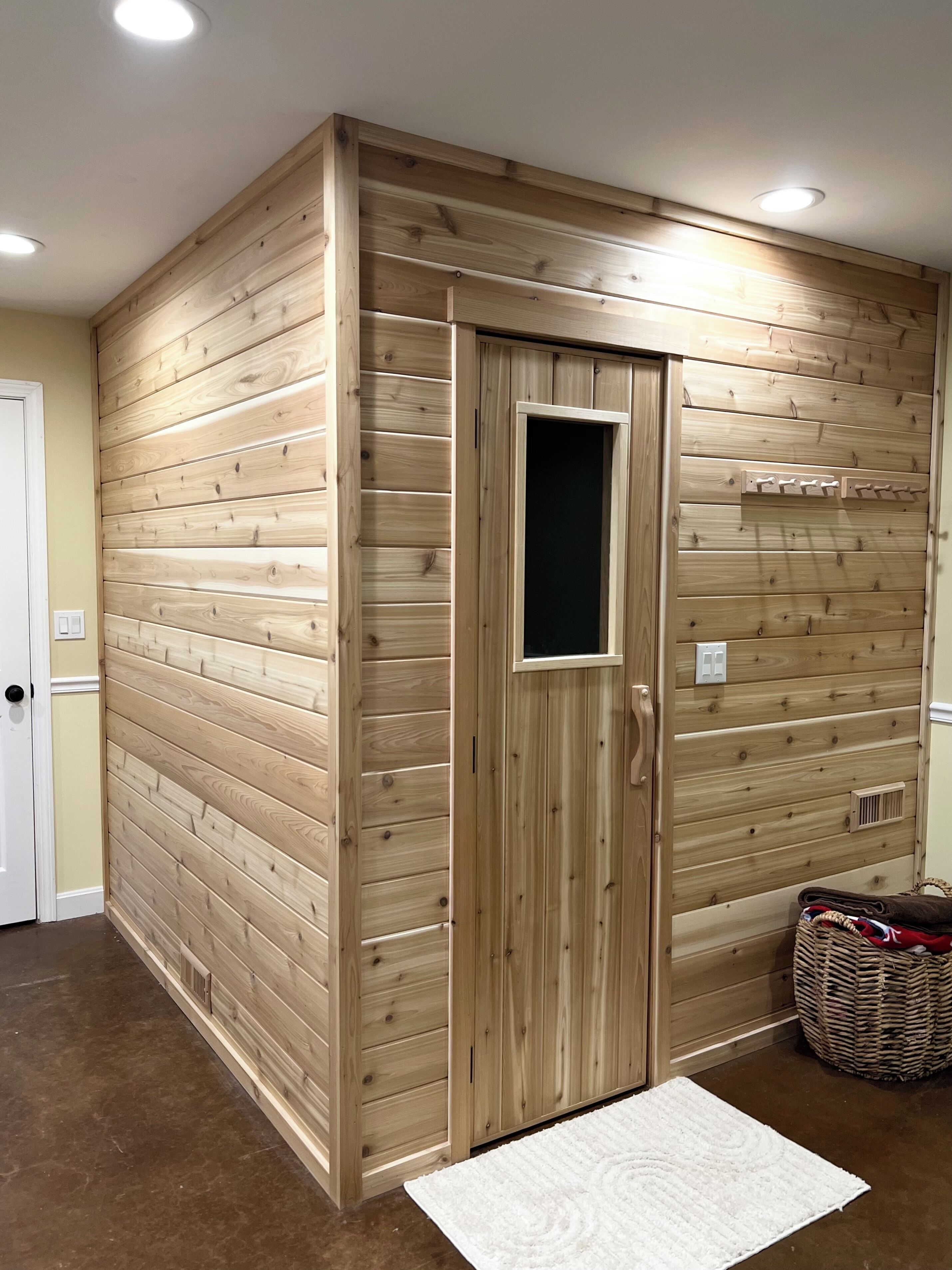 Ein Zimmer mit Holzwandverkleidung, einer weißen Tür und einem weißen Teppich auf dem Boden.